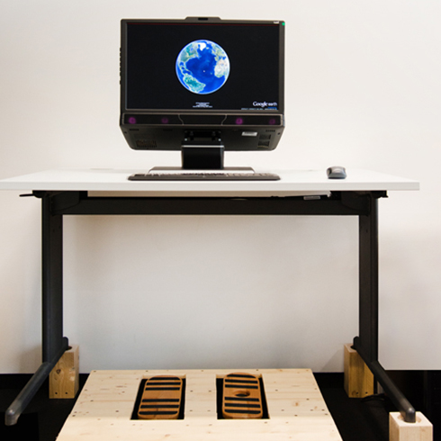 The photo shows the setup of the project consisting of a workstation with foot pedals and an eye tracker.